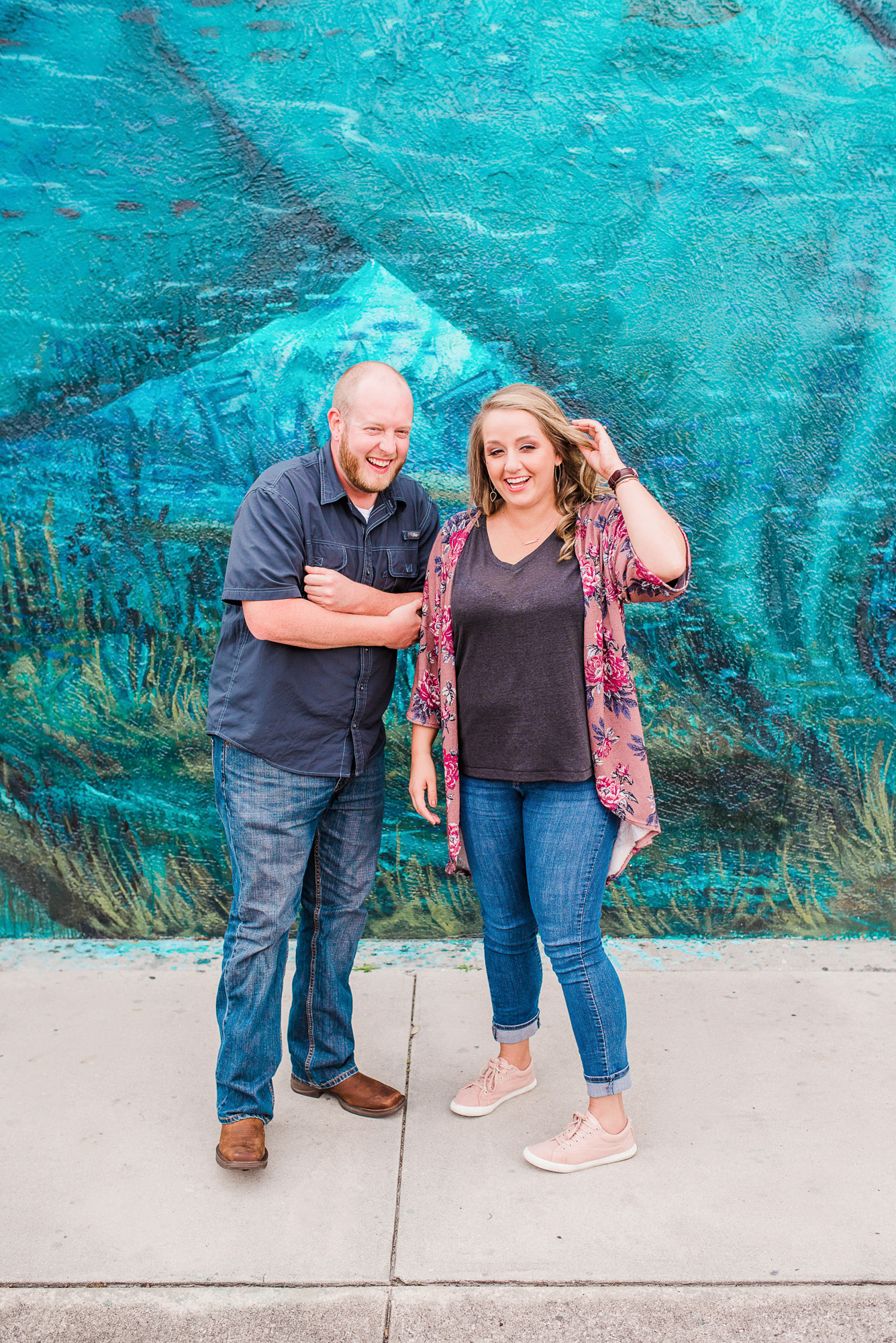 Couple laughing in front of blue mural in downtown Melbourne