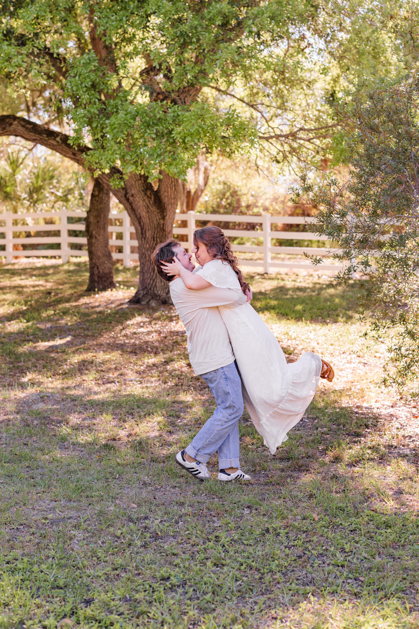 Man twirling woman under the oak trees at Up the Creek Farms