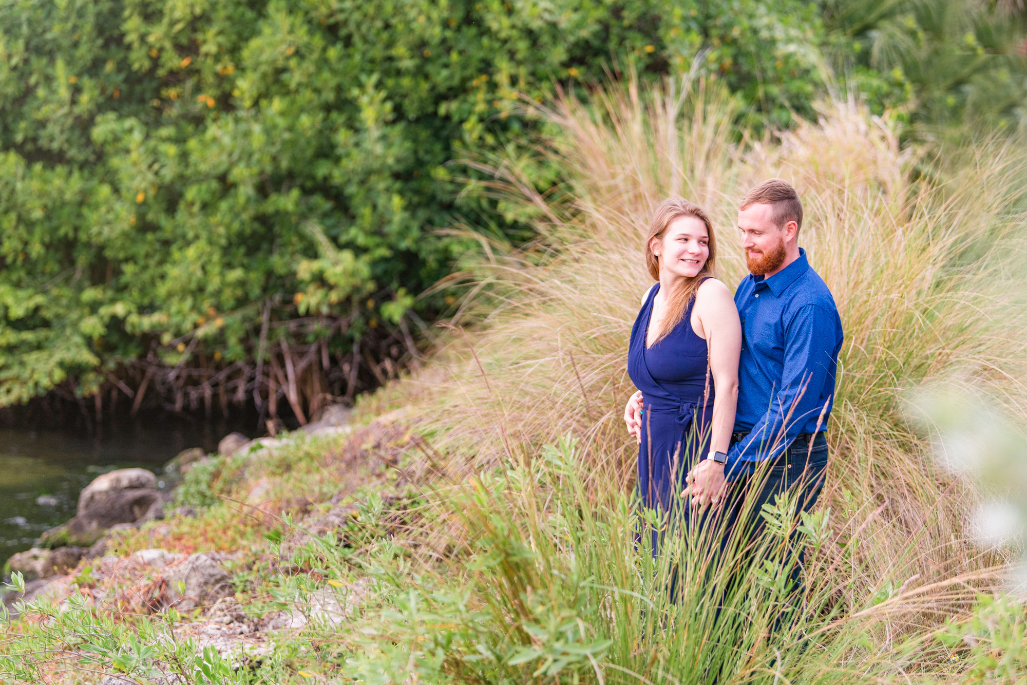 Couple hugging at the edge of the river in Melbourne Beach at the pier