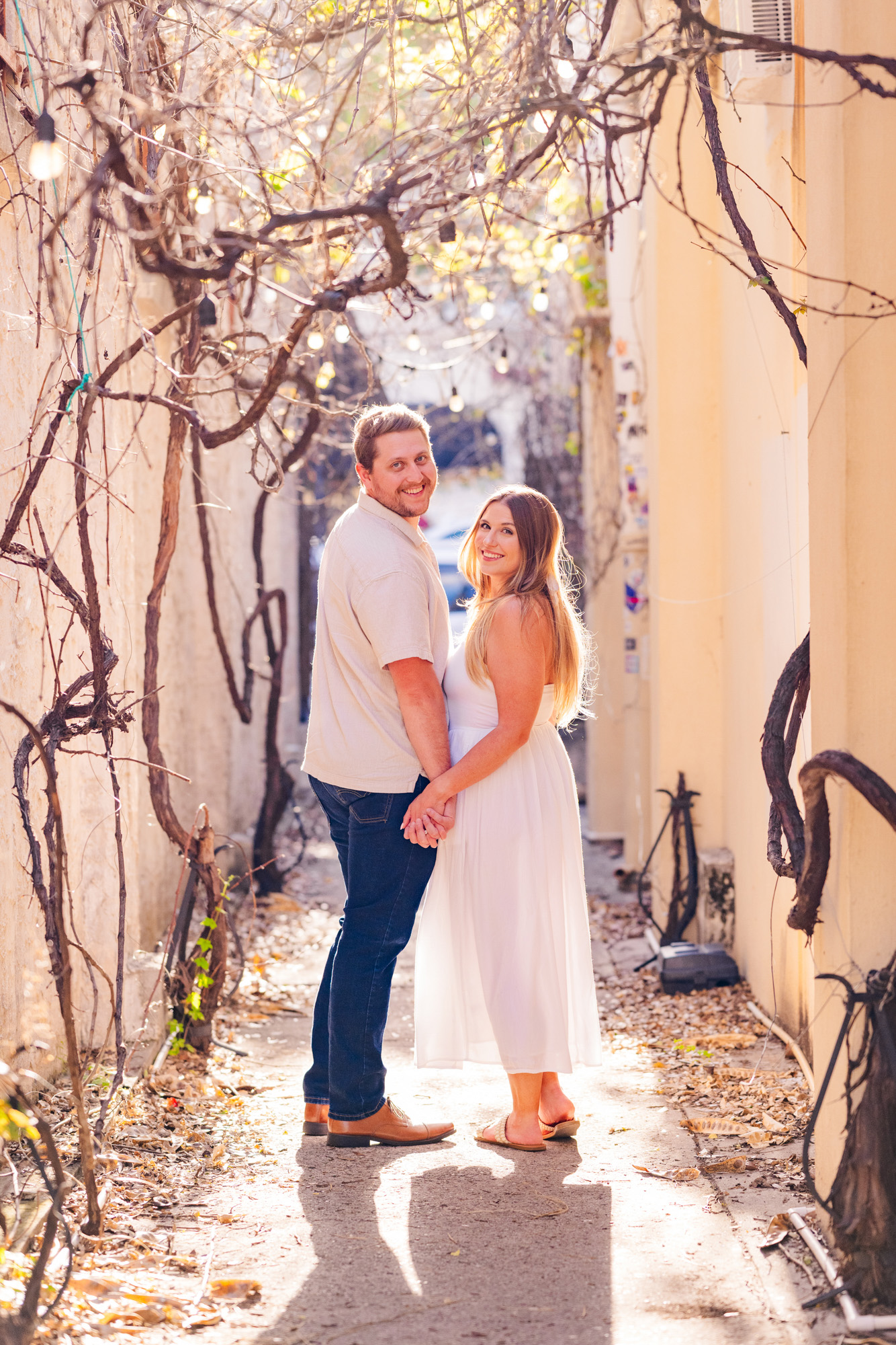 couple holding hands in an alley in Cocoa Village