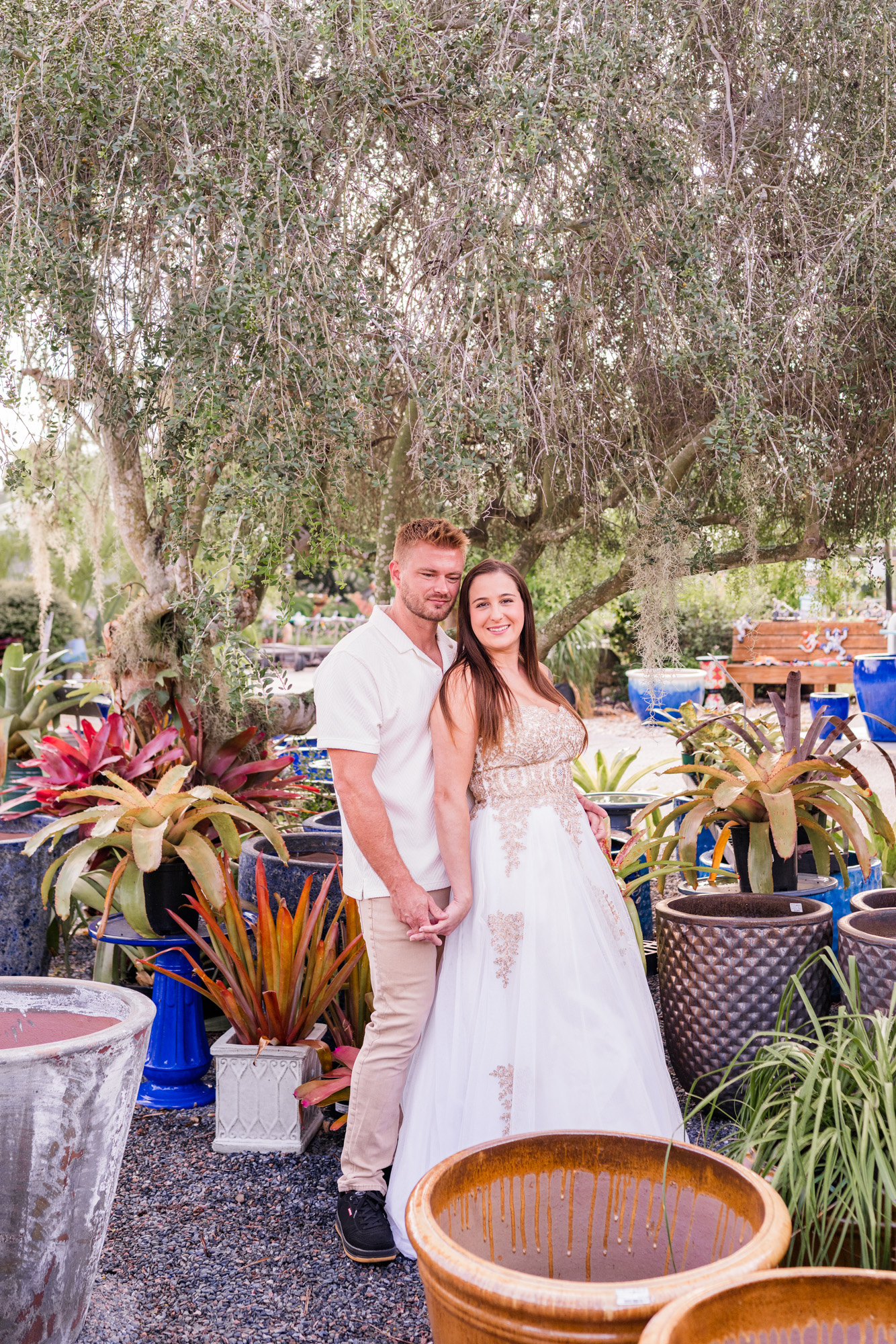 Couple holding hands in front of plants at Rockledge Gardens
