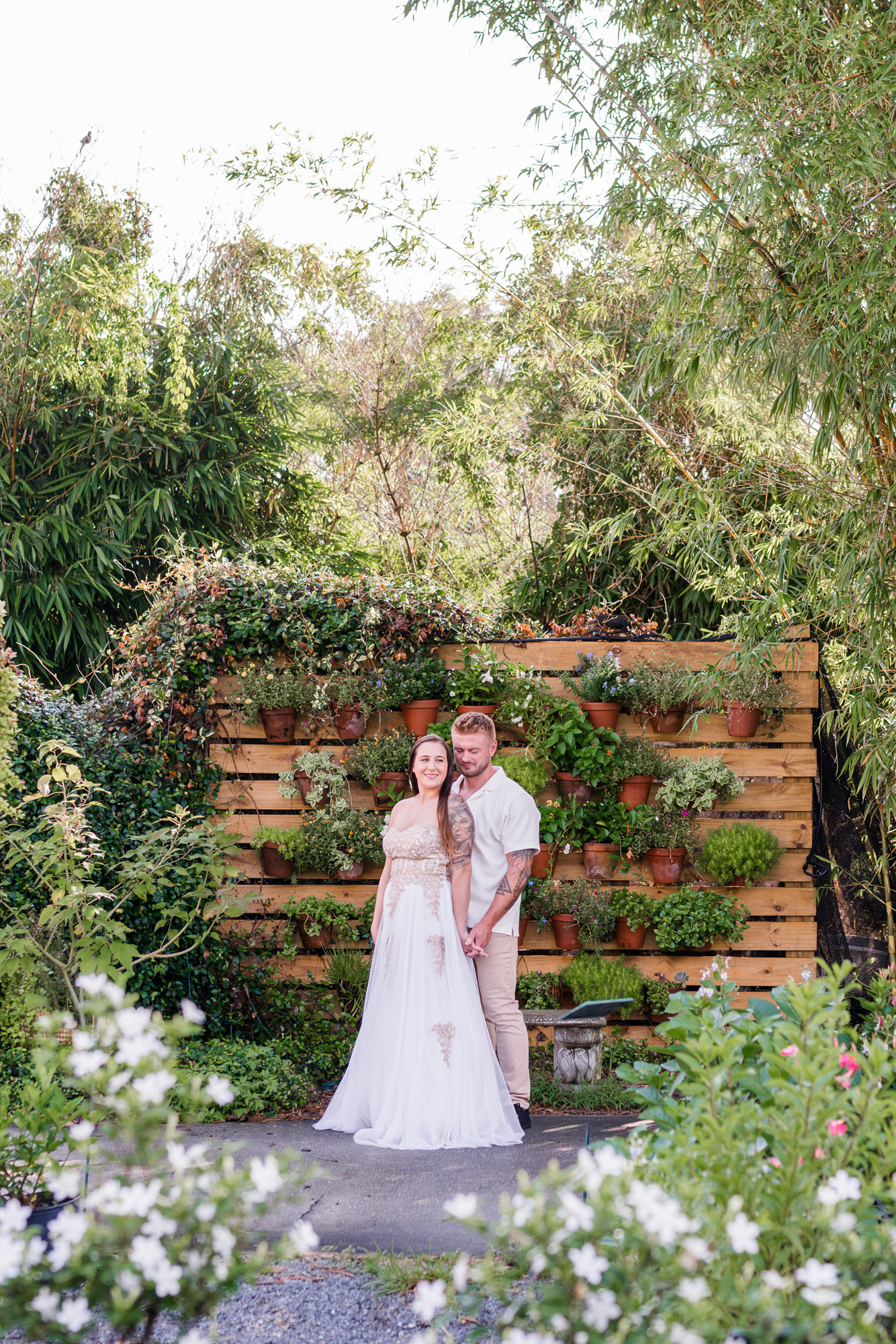 Couple hugging in front of the plant wall at Rockledge Gardens