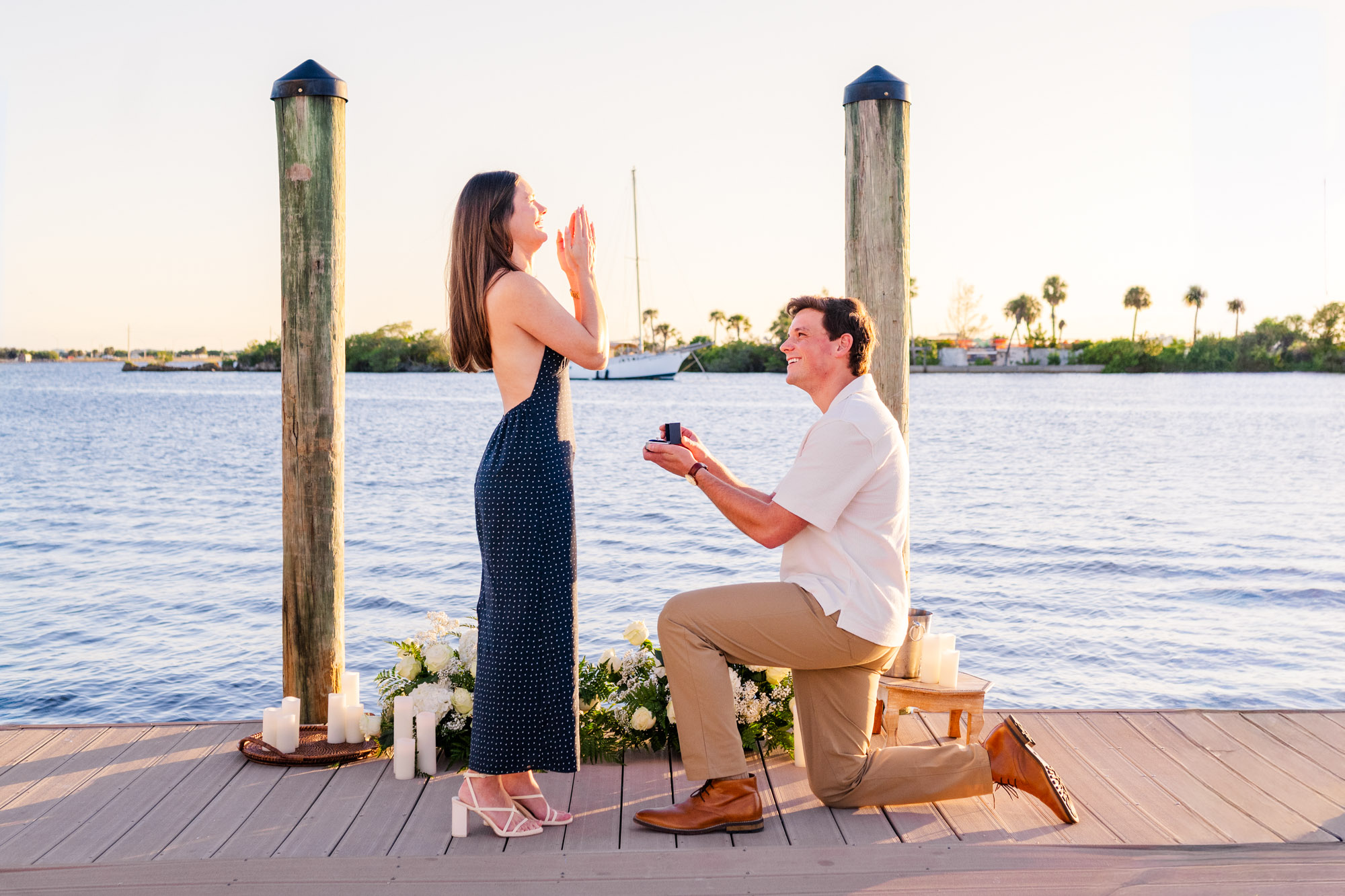 Man places an engagement ring on his partner's finger during a romantic dockside proposal in Melbourne, Florida.