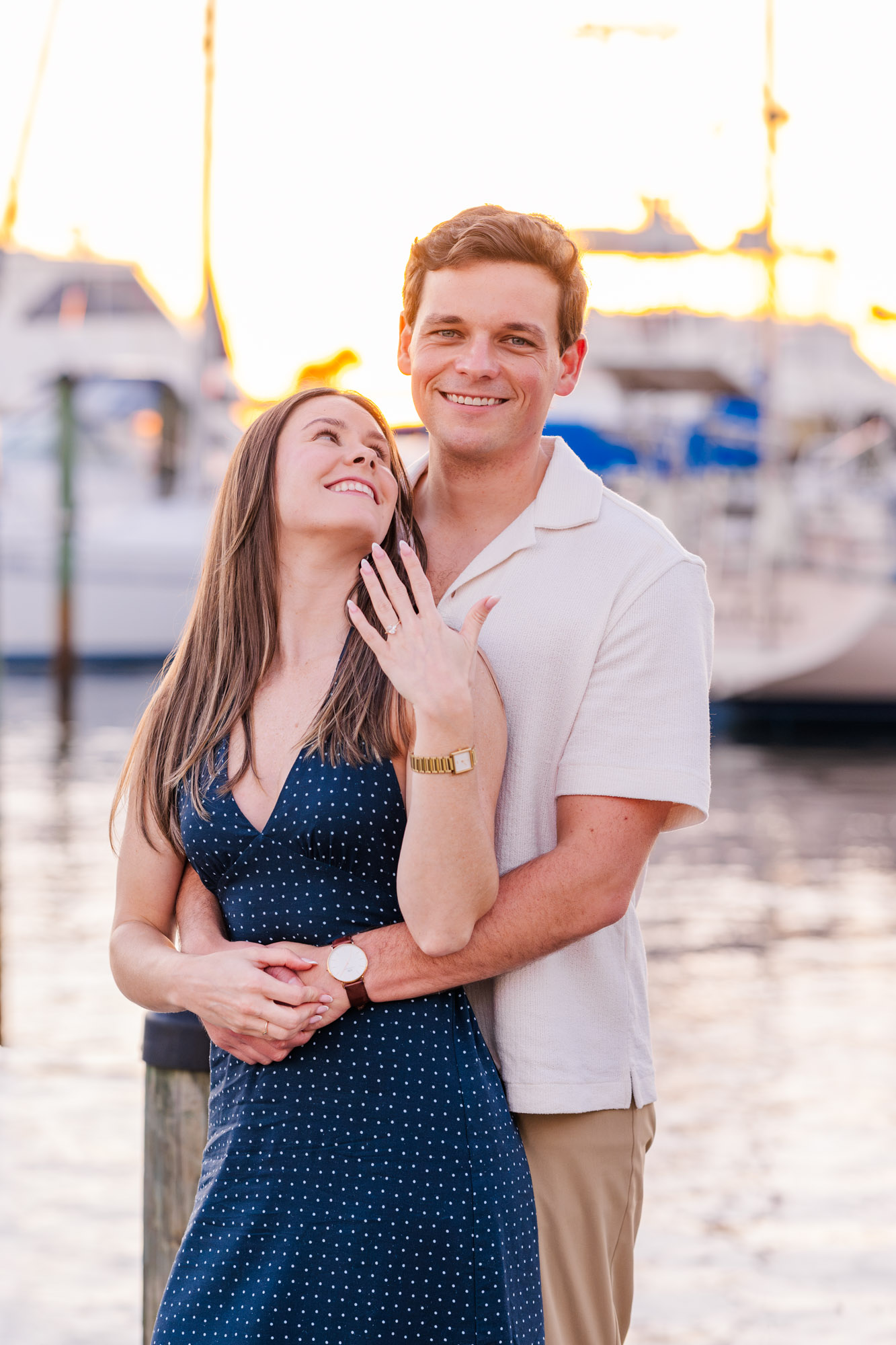 Couple smiling together as the bride-to-be displays her engagement ring during sunset portraits at Eau Gallie Yacht Club.