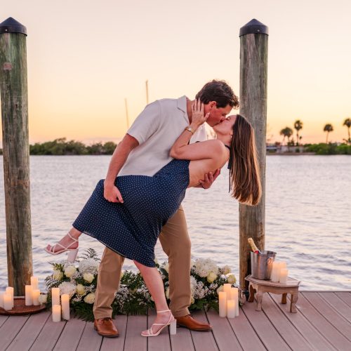 Man dipping his fiancée into a romantic kiss on the waterfront dock at Eau Gallie Yacht Club.