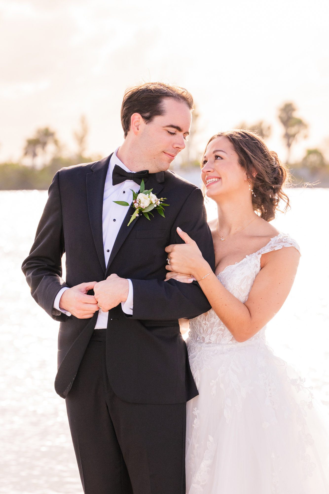 Bride hugging groom from behind at the Eau Gallie Yacht Club with groom looking at her