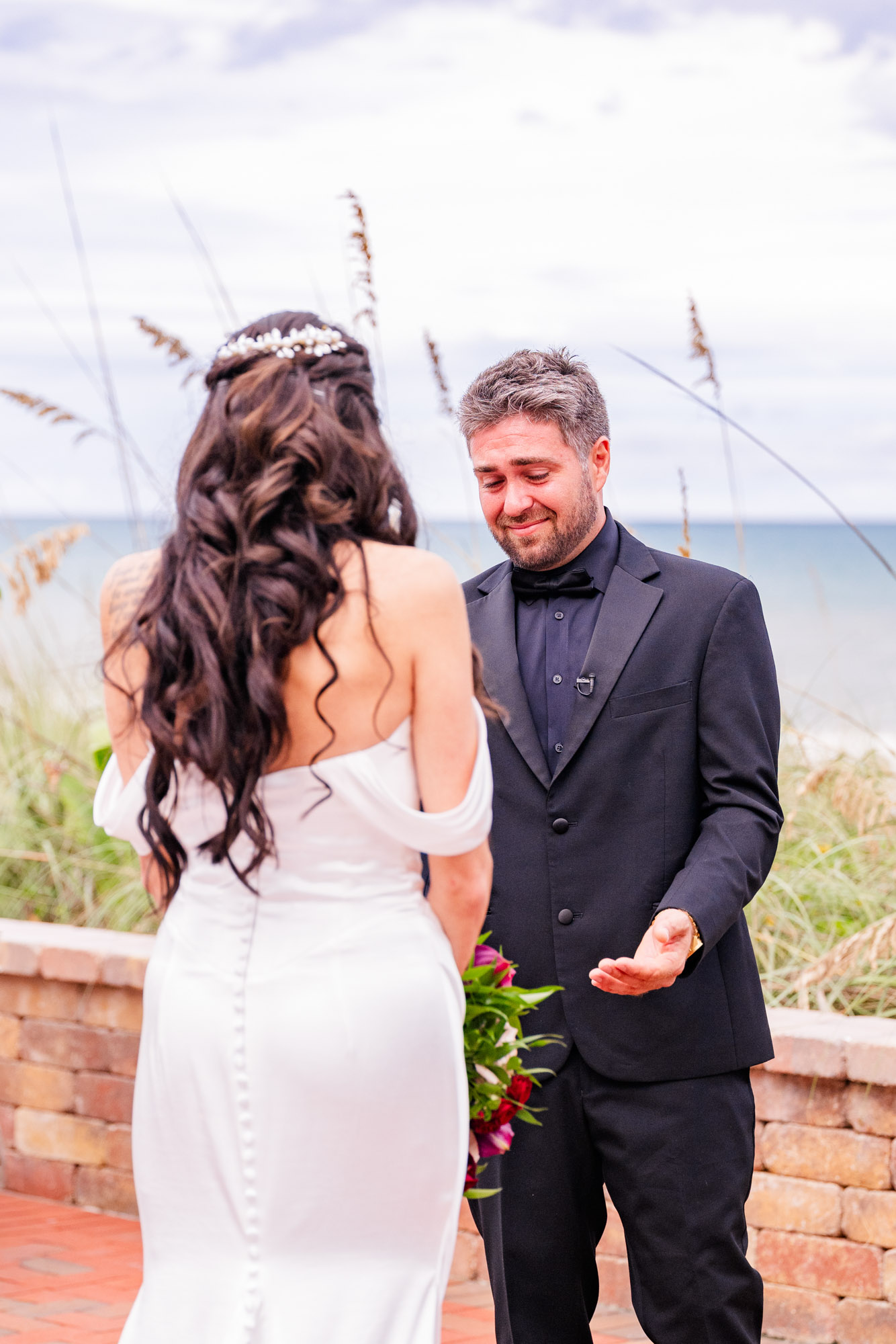 Bride and groom together in the sea oats at Harbour House Oceanfront, Melbourne Beach