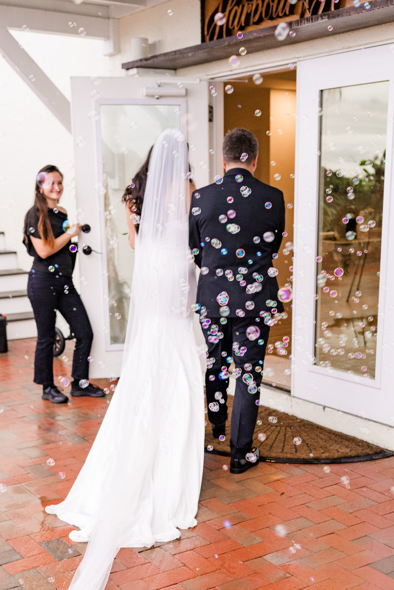 Bride and groom heading back inside through a cloud of bubbles after the ceremony