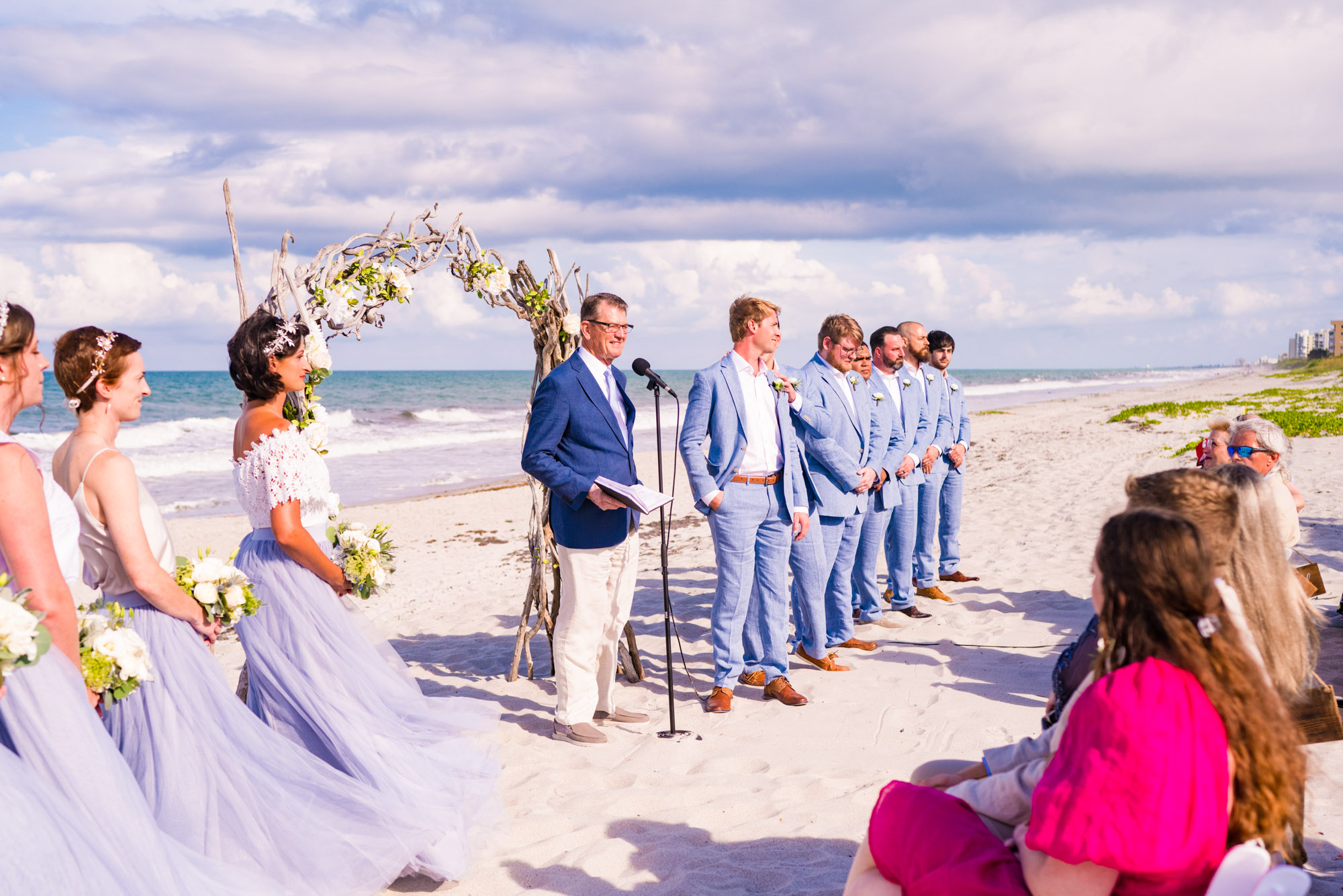 Groomsmen all lined up on the beach at Harbour House Oceanfront wedding venue.