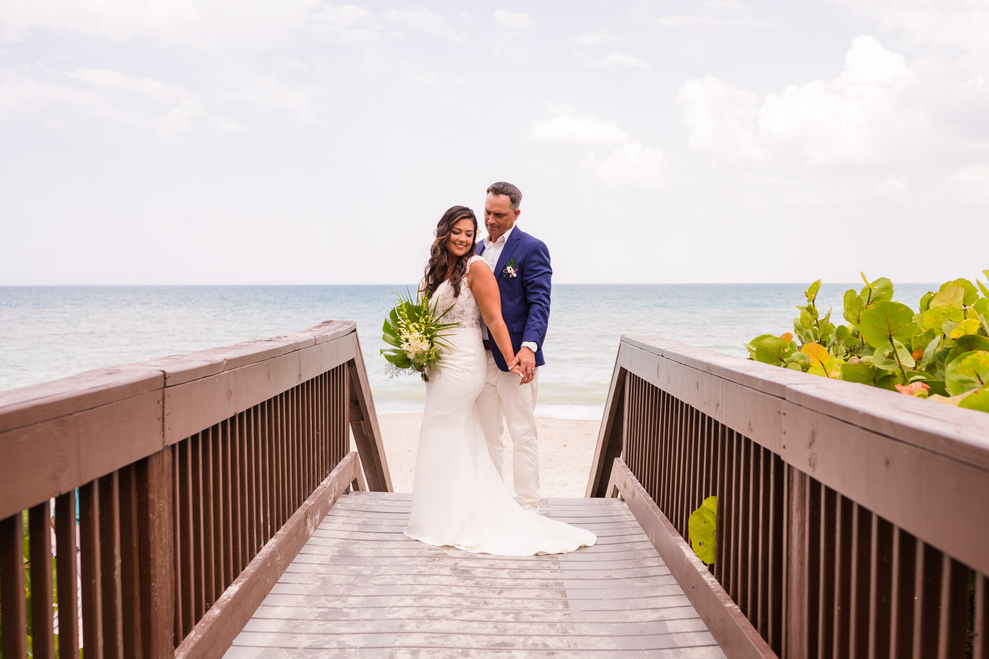 Couple holding hands on the walkway that leads to the beach at the Melbourne Beach Hilton Oceanfront