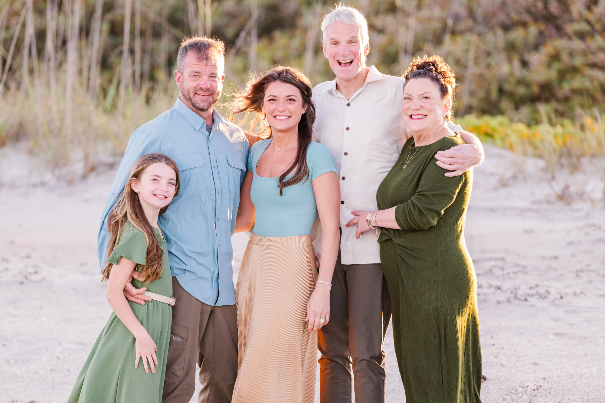 Multigenerational family smiling together on the beach in Melbourne Beach, Florida.
