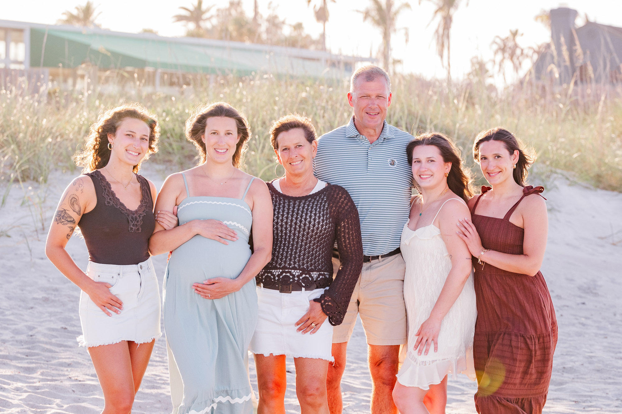 Extended family posing together on the beach at sunset in Melbourne Beach, Florida.