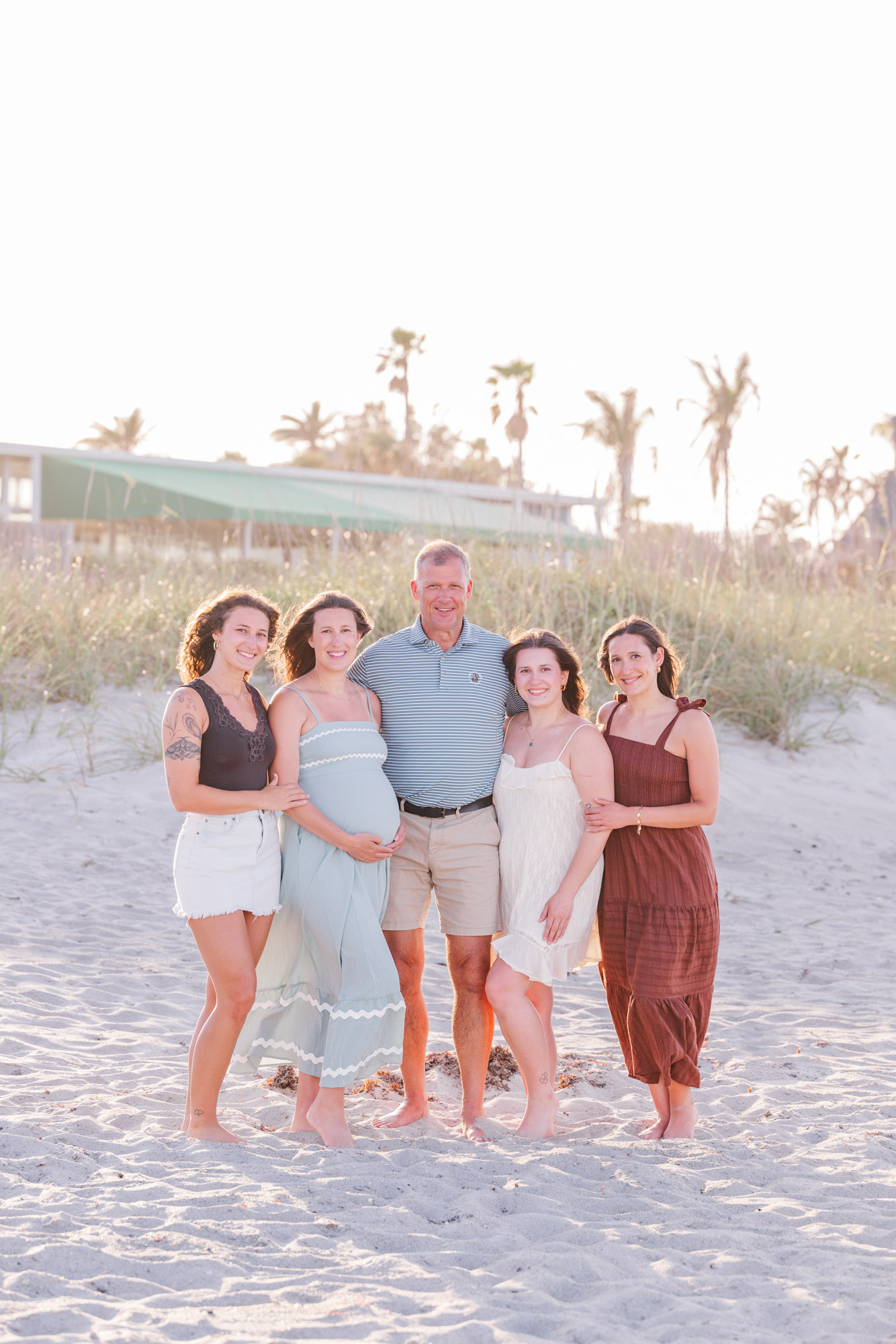 Family group posing together in soft evening light on a Florida beach.
