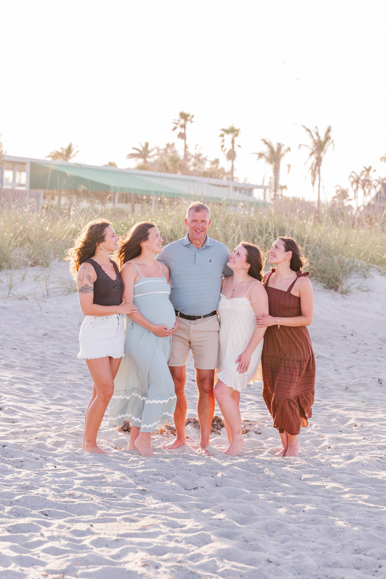 Family members laughing together during a relaxed beach portrait session.