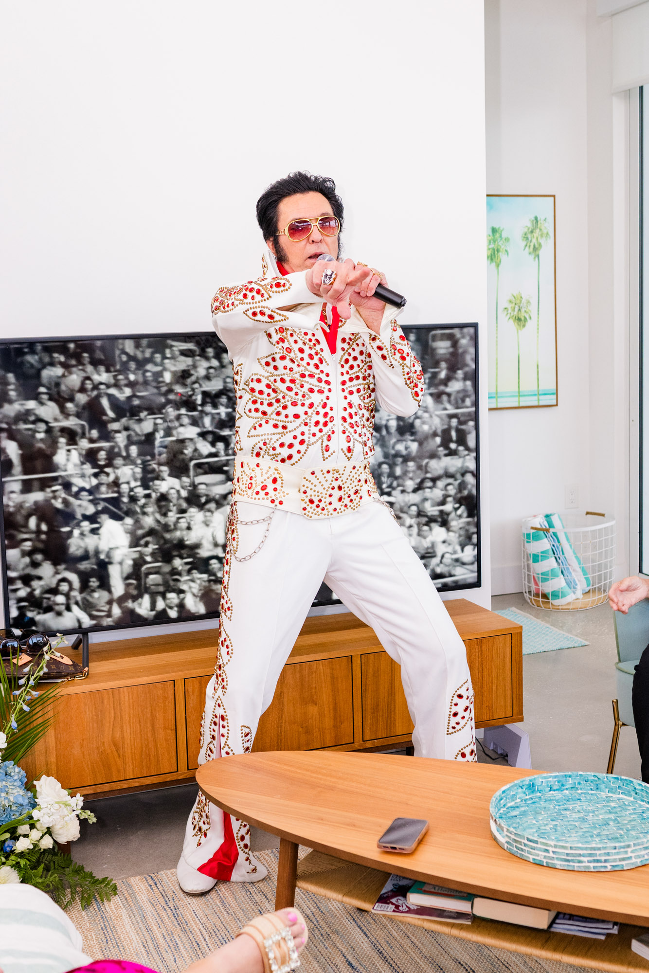 Elvis impersonator performing in a white rhinestone jumpsuit during a fun Airbnb wedding reception in Melbourne Beach.
