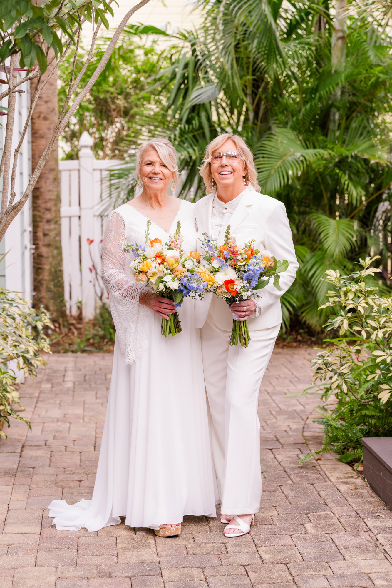 A full length picture of of two brides holding their bouquets in Melbourne Beach