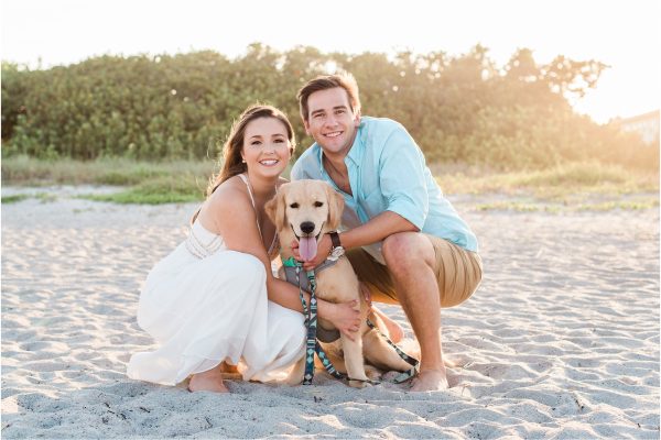 Couple cuddling with dog on beach Cocoa Beach Engagement