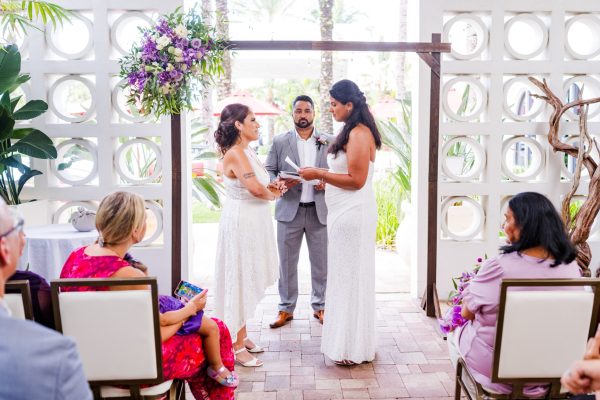 Two brides holding hands at the alter during a costa d'este wedding
