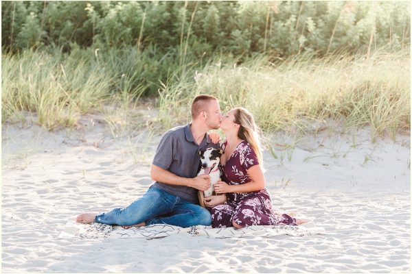 couple sitting on beach with dog Melbourne Florida engagement photographer