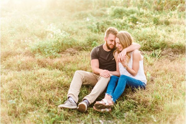 couple cuddling in field during Floridana Beach engagement