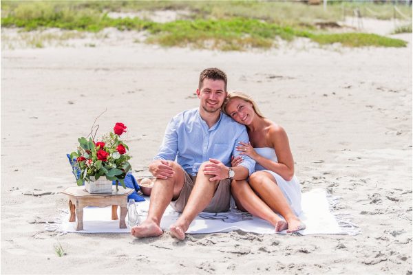 Couple cuddling on beach blanket