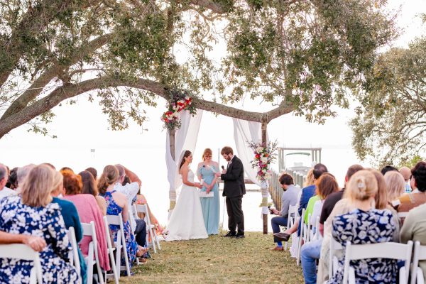 Wedding ceremony under trees on th edge of the Indian River Lagoon in Melbourne Beach, Florida